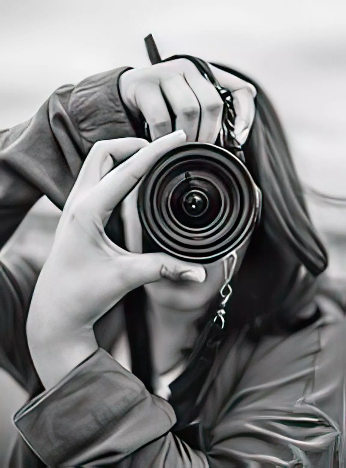 Лицо фотографа спрятано за объективом фотоаппарата во время съемки